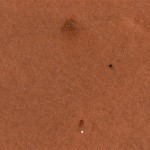 An enhanced-color image provided by NASA/JPL-Caltech/University of Arizona from Mars Reconnaissance Orbiter's High Resolution Imaging Science Experiment (HiRISE) camera shows the Phoenix landing area viewed from orbit. The spacecraft appears more blue than it would in reality. From top to bottom are the Phoenix lander with its solar panels deployed on the Martian surface, the heat shield and bounce mark the heat shield made on the Martian surface, and the top of the Phoenix parachute attached to the bottom of the back shell. (AP Photo/NASA/JPL-Caltech/University of Arizona. )