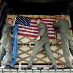 U.S. soldiers from Marine Aircraft Group 36 adjust flags on a cargo of UNICEF aid after loading it onto a cargo plane for cyclone victims in Myanmar, Friday, June 6, 2008, in Medan, North Sumatra, Indonesia. The plane was due to fly the aid first to Thailand from where it would be flown into Yangon. (AP Photo/Binsar Bakkara)
