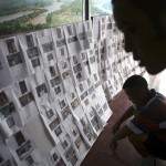 People look at photos of victims who died in the May 12 earthquake at a funeral home in Dujiangyan, in southwest China's Sichuan province Tuesday, June 10, 2008. The 7.9 magnitude quake on May 12 killed 69,146 people, and 17,516 are still missing, the government said late Tuesday. About 5 million people were made homeless. (AP Photo/Color China Photo)
