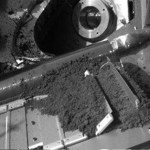 This image provided by NASA shows Martian soil retrieved by the robotic arm of NASA's Phoenix Mars Lander and released onto a screened opening of the lander's tiny testing oven Friday, June 6, 2008. The soil failed to reach the instrument and scientists said Saturday they will devote a few days to trying to determine the cause. (AP Photo/NASA)
