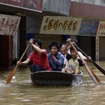 Residents row a boat at a flooded area near the Xijiang (West River) at the Fengkiu county of Zhaoqing in China's southern Guangdong province Wednesday, June 18, 2008. Flood waters have started to recede in parts of southern China after killing at least 63 people, swamping millions of acres of farmland and causing billions of dollars in damage, the government said. (AP Photo/Vincent Yu)