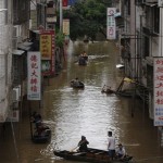 Residents row boats at a flooded area near the Xijiang (West River) at the Fengkiu county of Zhaoqing in China's southern Guangdong province Wednesday, June 18, 2008. Flood waters have started to recede in parts of southern China after killing at least 63 people, swamping millions of acres of farmland and causing billions of dollars in damage, the government said. (AP Photo/Vincent Yu)