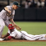 Arizona Diamondbacks' Justin Upton is tagged out by Oakland Athletics second baseman Mark Ellis on a steal-attempt during the first inning of a baseball game Thursday.