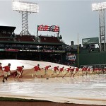 The grounds crew pulls the tarp off the infield at Fenway Park after a rainstorm delayed the start of the baseball game between the Boston Red Sox and the Arizona Diamondbacks in Boston, Tuesday.