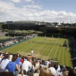Crowds watch the Men's Singles, second round match between Chile's Fernando Gonzalez, rear, and Italy's Simone Bolelli, on Court 18 at Wimbledon, Wednesday. The Centre Court is in background.