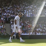 Switzerland's Roger Federer walks across the court as a shaft of late afternoon light illuminates the Centre Court during his second round match against Sweden's Robin Soderling at Wimbledon, Wednesday.