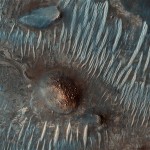 This image provided by NASA shows an area located west of the Nili Fossae trough on Mars, one of the proposed landing sites for the Mars Science Laboratory. The image was taken by the Mars Reconnaissance Orbiter. The dark terrain is fairly featureless in some areas, whereas other parts, when zoomed in to high resolution, show ripples, sand deposits resulting from wind activity. The lighter terrain is bedrock. The green and bluish colors represent a composition rich in mafic (iron- and magnesium-rich) minerals such as pyroxene and maybe olivine, with green having the greatest concentration. The green-blue material at the upper right is mostly rock, whereas the materials in the bedforms (at left) are composed of sand. The reddish materials are composed of magnesium- and iron-rich clays, possibly formed by ancient water that altered volcanic rock. In this scenario, the polygonal texture could represent cracks formed after the clays dried. (AP Photo/NASA)
