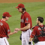 Arizona Diamondbacks' Bob Melvin, left, pulls pitcher Randy Johnson, center, from the game as catcher Miguel Montero looks on during a baseball game against the Milwaukee Brewers in the fourth inning Tuesday.