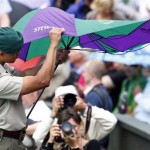 A security officer struggles with an umbrella as rain stops play on Centre Court for the men's quarterfinal match between Switzerland's Roger Federer and Croatia's Mario Ancic at Wimbledon, Wednesday, July 2, 2008. (AP Photo/Kirsty Wigglesworth)