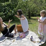 Michelle Hovis, left, watches as her children Katie Blaine, center, 5, and Lilly, left, 3, blow bubbles after a picnic outside their home in Iron Station, N.C., Tuesday, June 17, 2008. As inflation squeezes budgets, middle-class Americans are taking fresh stock of their everyday habits in search of ways to curb spending. (AP Photo/Chuck Burton)
