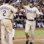 San Diego Padres' Scott Hairston, right, is greeted at homeplate by teammates Edgar Gonzalez (2) and Luke Carlin, second from left, after Hairston hit a two-run home run off Arizona Diamondbacks pitcher Doug Davis (not shown) in the third inning of a baseball game Saturday, July 5, 2008, in Phoenix.(AP Photo/Paul Connors)