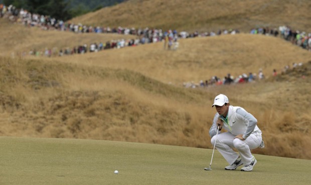 Rory McIlroy, of Northern Ireland, lines up his putt on the 13th hole during the first round of the...