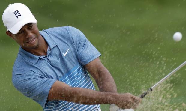 Tiger Woods hits from the sand on the 18th hole during a practice round for The Memorial golf tourn...