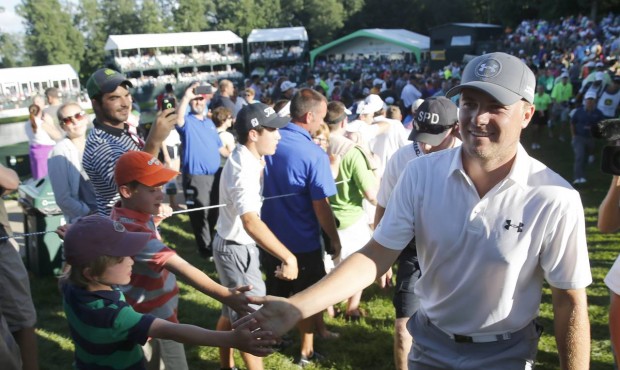 Jordan Spieth, right, celebrates with fans after finishing the third round of the John Deere Classi...