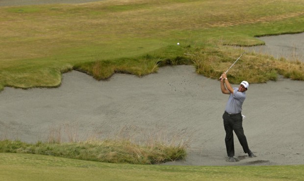 Phil Mickelson hits out of the bunker on the 13th hole during the first round of the U.S. Open golf...