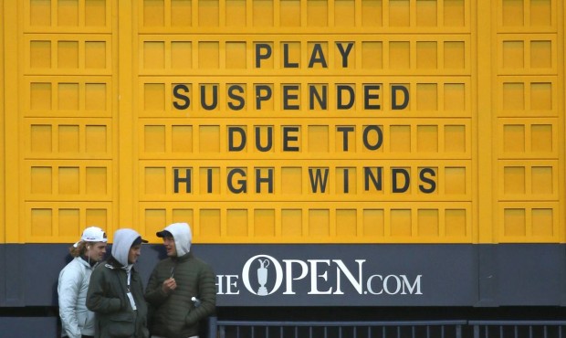 A scoreboard near the 18th hole announces that play has been suspended due to high winds during the...