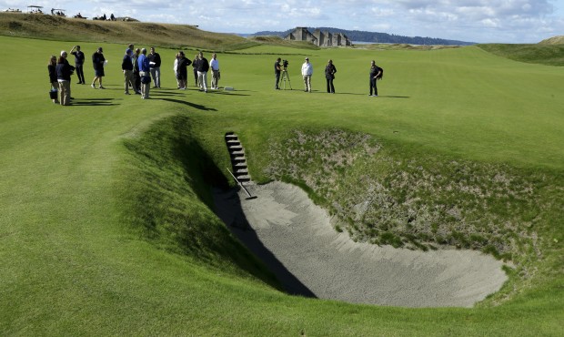 In this Sept. 30, 2014, photo, reporters and photographers stand near the deep pot bunker on the 18...