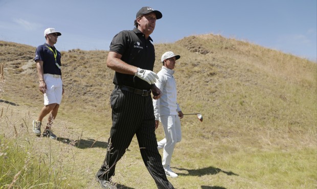 Rickie Fowler, right, and Phil Mickelson walk on the 11th hole during a practice round for the U.S....