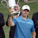 
              Rory McIlroy, of Northern Ireland, raises the trophy after winning the Wells Fargo Championship golf tournament at Quail Hollow Club in Charlotte, N.C., Sunday, May 17, 2015. (AP Photo/Bob Leverone)
            