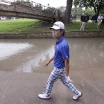 
              Kevin Na walks next to a rain-swollen drainage culvert adjacent to the 18th fairway where he lost his ball during the second round of the Colonial golf tournament, Friday, May 22, 2015, in Fort Worth, Texas. Na recovered for par on the hole. (AP Photo/LM Otero)
            