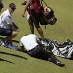 
              Jason Day, of Australia, lies in the fairway after falling down as his caddie Colin Swatton crouches beside him on the ninth hole during the second round of the U.S. Open golf tournament at Chambers Bay on Friday, June 19, 2015 in University Place, Wash. (AP Photo/Ted S. Warren)
            
