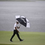 
              Whee Kim, of South Korea, walks in the rain toward the third hole during the final round of the Barbasol Championship golf tournament Sunday, July 19, 2015, in Opelika, Ala. (AP Photo/Butch Dill)
            