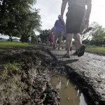 
              Spectators make their way through the muddy  gallery during the third round of the Byron Nelson golf tournament, Saturday, May 30, 2015, in Irving, Texas. (AP Photo/LM Otero)
            