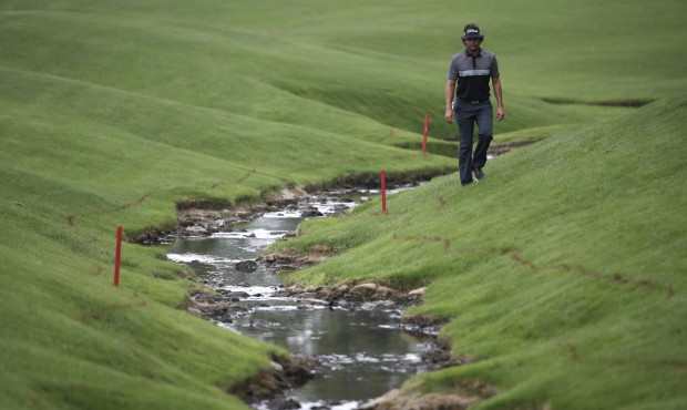 Martin Flores walks to his ball by the creek on the 18th hole during the second round of the Wells ...