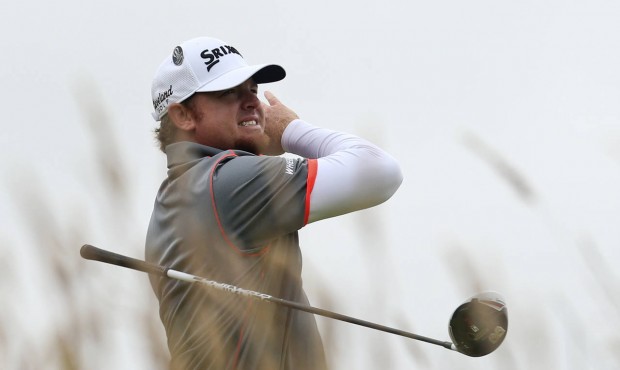 n United States’ J.B. Holmes lets go of his club after hitting a wayward shot on the 15th hole du...