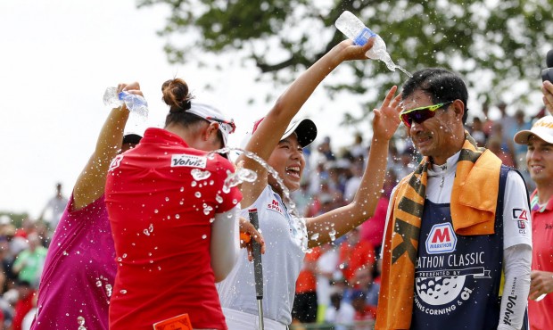 Chella Choi, front left, of South Korea, and her father and caddie Ji Yeon Choi, right, are doused ...
