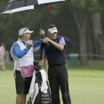 
              Ian Poulter, right, listens to his caddie Terry Mundy while under an umbrella before an approach shot on the ninth hole during the second round of the Colonial golf tournament, Friday, May 22, 2015, in Fort Worth, Texas. (AP Photo/LM Otero)
            