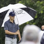 
              Jordan Spieth uses an umbrella as his playing partners putt on the seventh green during the final round of the Colonial golf tournament, Sunday, May 24, 2015, in Fort Worth, Texas. (AP Photo/LM Otero)
            