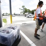 
              Ticket takers stand by a box containing American flags, left, to hand out to race fans that request one in exchange for a Confederate flag at the entrance to Daytona International Speedway for this weekends races, Friday, July 3, 2015, in Daytona Beach, Fla. (AP Photo/John Raoux)
            