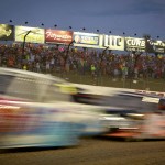 
              Trucks race past stands along the back stretch early in the NASCAR Trucks Series' Mud Summer Classic auto race at Eldora Speedway in Rossburg, Ohio, Wednesday, July 22, 2015. (Jim Witmer/The (Dayton) Daily News via AP)
            