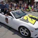 
              NASCAR driver Jeff Gordon, left, waves to fans along the parade route in Pittsboro, Ind., Thursday, July 23, 2015. Pittsboro, had a parade for Gordon as part of his  farewell tour.  Gordon will drive in Sunday's Brickyard 400.  (AP Photo/Michael Conroy)
            