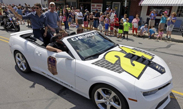 n NASCAR driver Jeff Gordon, left, waves to fans along the parade route in Pittsboro, Ind., Thursda...