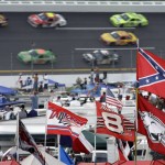 
              FILE - In this Oct. 7, 2007, file photo, a Confederate flags fly in the infield as cars come out of turn one during a NASCAR auto race at Talladega Superspeedway in Talladega, Ala. NASCAR  backed South Carolina Gov. Nikki Haley's call this week to remove the Confederate flag from the Statehouse grounds in the wake of the Charleston church massacre. Though NASCAR now bars the use of the flag in any "official capacity," they are as easy to find at NASCAR races as cutoff jeans, cowboy hats, and beer. (AP Photo/Rob Carr, File)
            