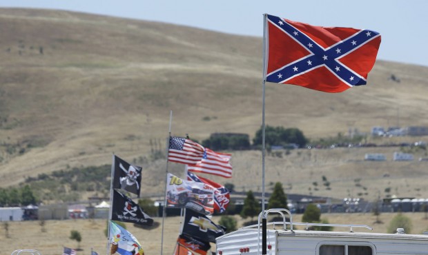 A number of flags, including a Confederate-themed one, fly atop RV’s in a campground outside ...