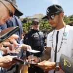 
              Mercedes driver Lewis Hamilton of Britain signs autographs in the pit lane at the Monaco racetrack, in Monaco, Friday, May 22, 2015. The Formula one race will be held on Sunday. (AP Photo/Claude Paris)
            
