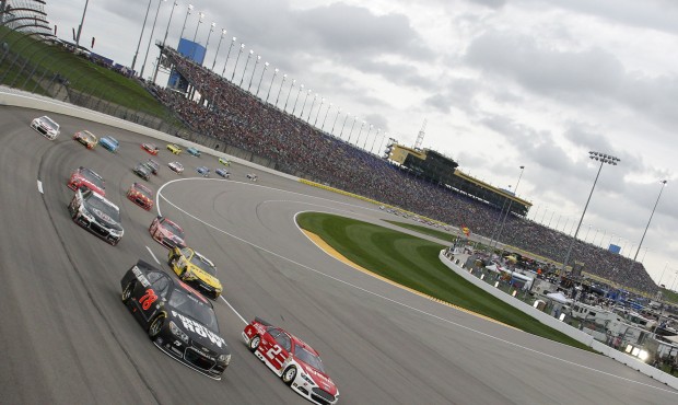 NASCAR driver Joey Logano (22) leads the first lap during a Sprint Cup Series auto race at Kansas S...