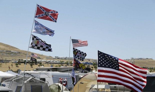 A number of flags, including a Confederate themed one, fly atop RV’s in a campground outside ...