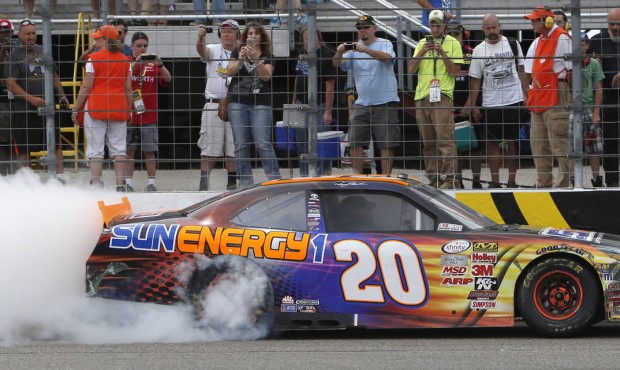 Denny Hamlin burns out before fans after winning the NASCAR XFINITY Cup series Lakes Region 200 at ...