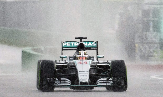 Mercedes driver Lewis Hamilton, of Great Britain, heads onto a rain soaked track during the second ...
