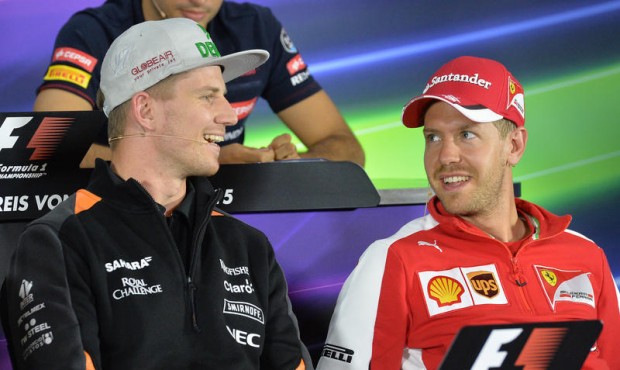 Force India driver Nico Huelkenberg of Germany and Ferrari driver Sebastian Vettel of Germany, righ...