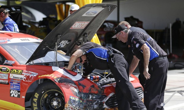 Crew members for Greg Biffle repair damage to his car after he was involved in a wreck during a NAS...