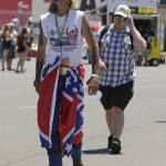 
              T.J. Woodward, left, of Sonoma, Calif., walks past the infield concession stand with a Confederate flag around his waist during practice for the NASCAR Sprint Cup Series auto race Friday, June 26, 2015, in Sonoma, Calif. (AP Photo/Eric Risberg)
            