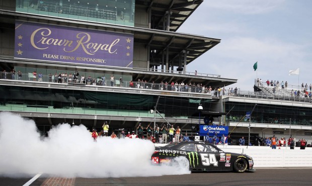 Kyle Busch does a burnout on the front straight after winning the NASCAR Xfinity Series auto race a...