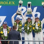 
              Nine time winner Tom Kristensen of Denmark gives the trophy to the Porsche 919 Hybrid No19 Team, from left, Earl Bamber of New Zealand, Nick Tandy of Great Britain and Nico Hulkenberg of Germany, during the podium ceremony of the 83rd 24-hour Le Mans endurance race, in Le Mans, western France, Sunday, June 14, 2015. (AP Photo/David Vincent)
            