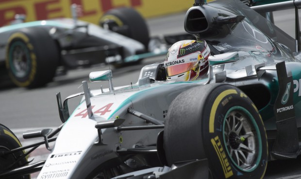 Mercedes driver Lewis Hamilton, of Great Britain, steers his car at the hairpin followed by team ma...