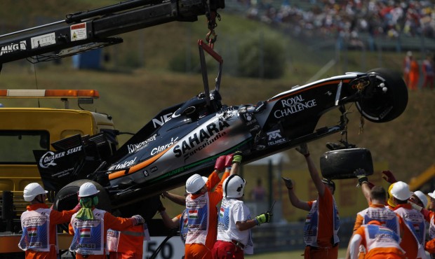 The car of Force India driver Sergio Perez of Mexico is removed by a crane after crashing, during t...